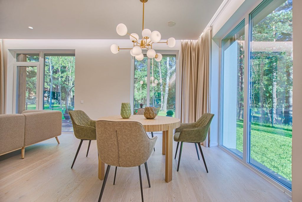 round-brown-wooden-5-piece-dining-set-in-room-1571463 Elegant dining room featuring modern furniture and large windows for natural light.